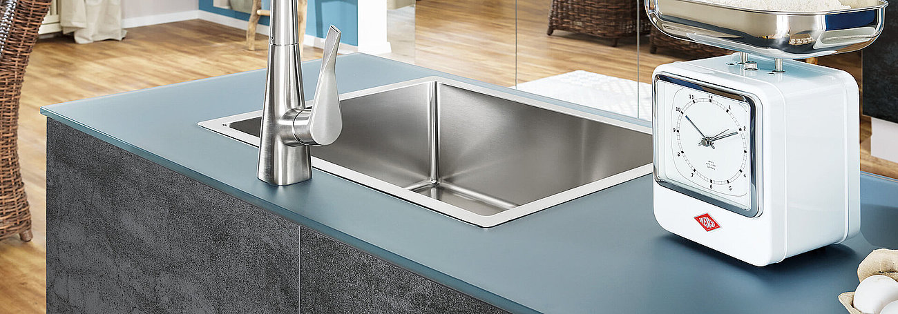 Glas-Arbeitsplatte in petrol-blau über Unterschrank mit Unterbau-Spüle